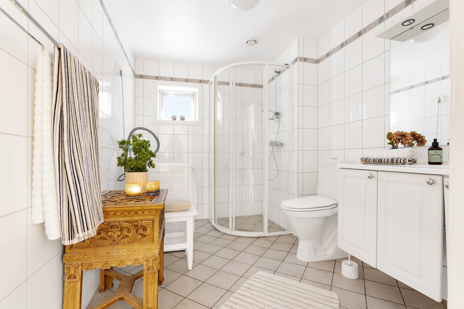 Badet har lyse overflater og opplegg for vaskemaskin. Galleribilde