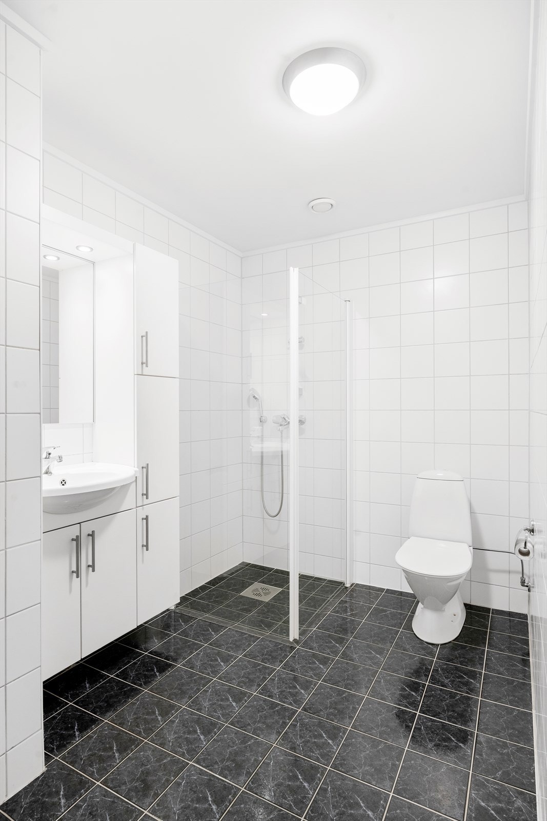 Pent, komplett flislagt bad med praktiske innredninger. Galleribilde