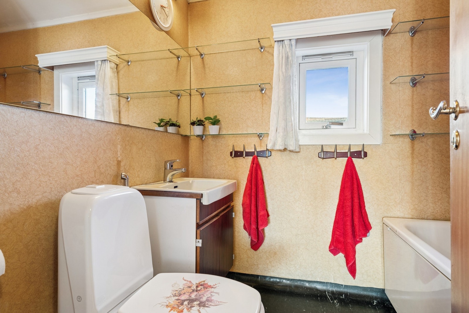 Badet er innredet med nedfeltservant, toalett og badekar. Galleribilde