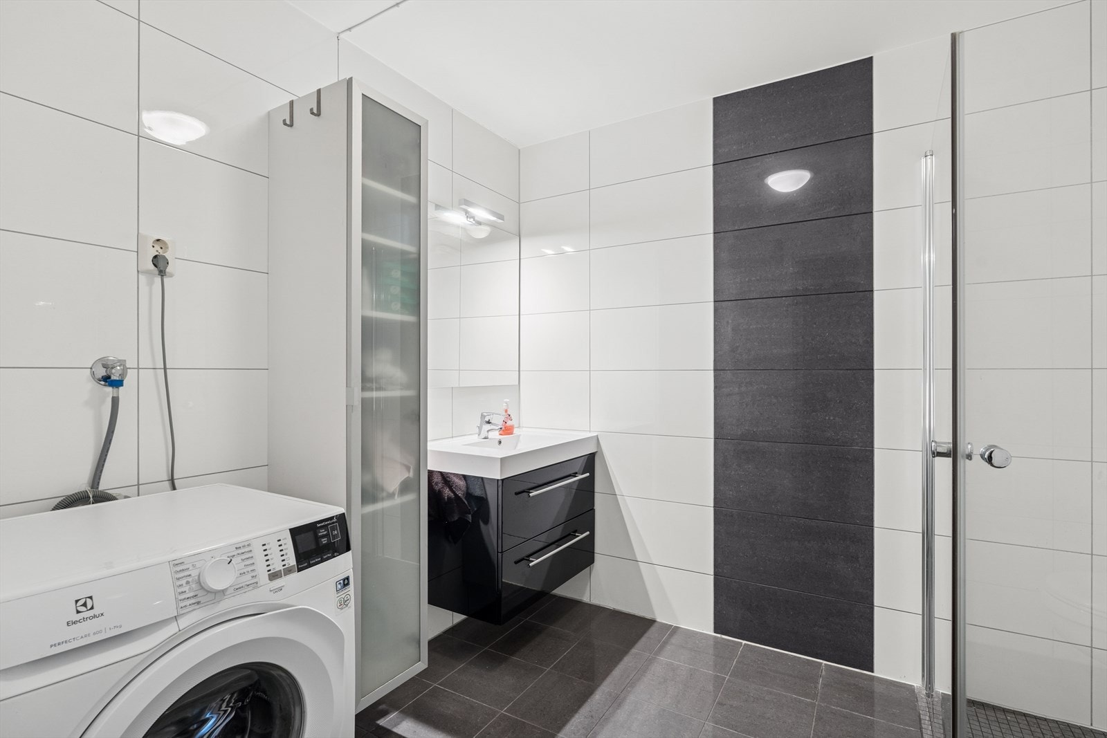 På badet er det dusjnisje, vegghengt toalett, baderomsinnredning, samt opplegg for vaskemaskin Galleribilde