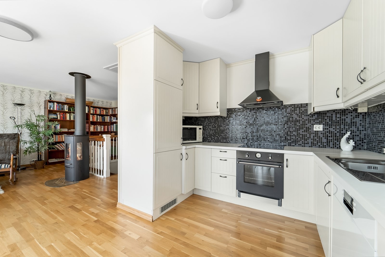 Åpen kjøkkenløsning mot stua med naturlig avgrensning. Galleribilde