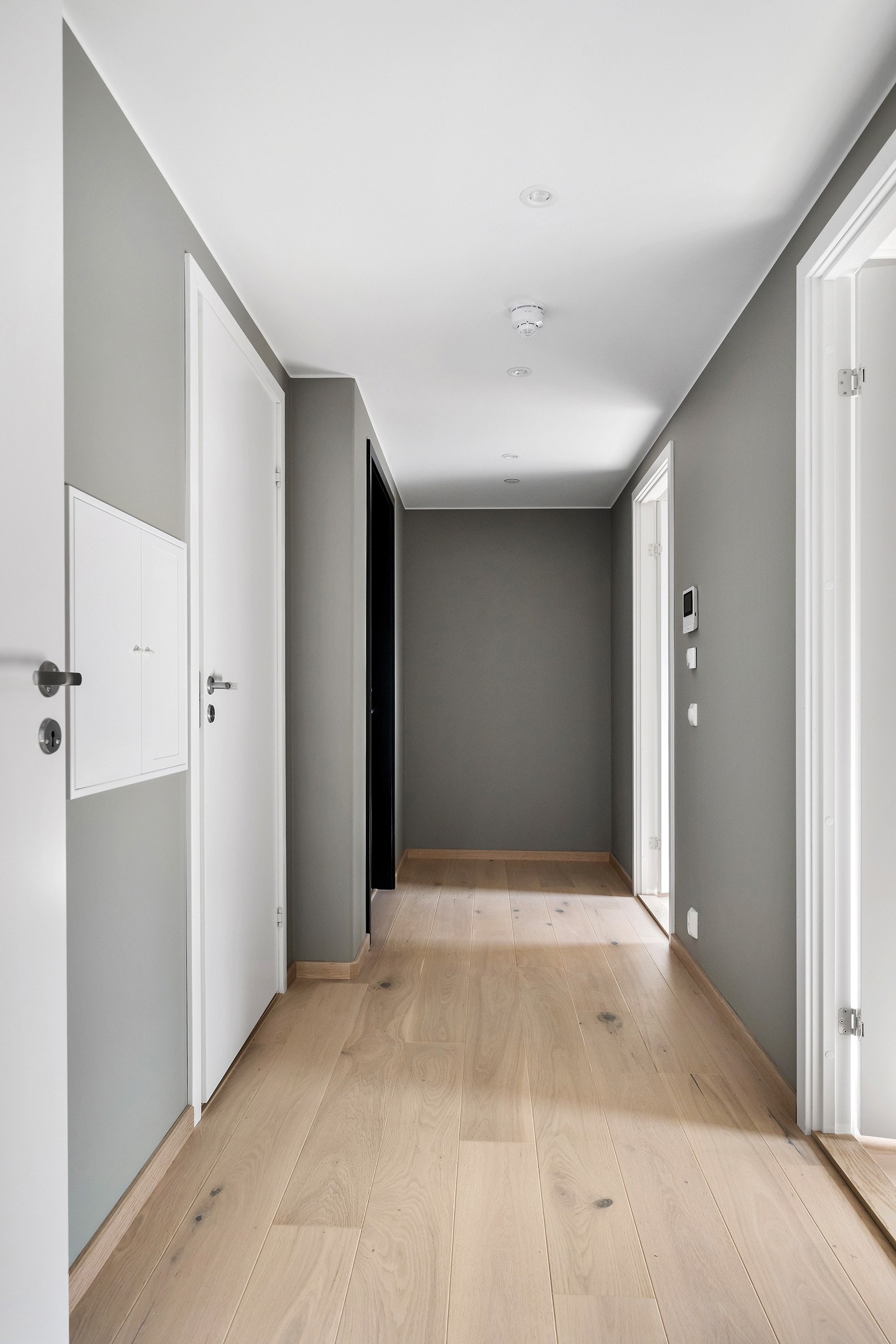 Innenfor inngangsdøren møtes du av en lys og innbydende entré med hvitpigmentert eikeparkett på gulv og vannbåren varme. Galleribilde