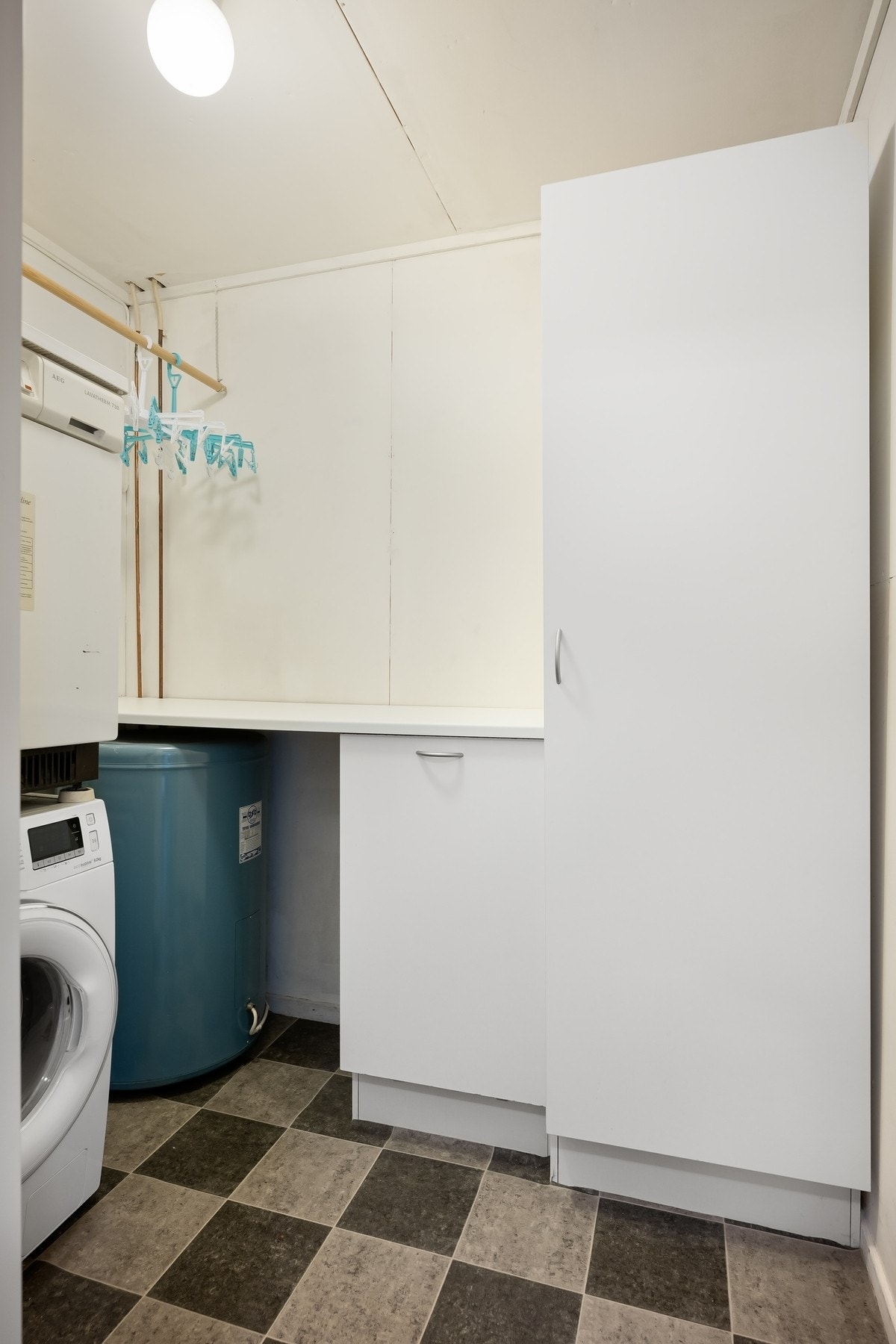 Praktisk vaskerom med opplegg for vaskemaskin og oppbevaringsplass Galleribilde