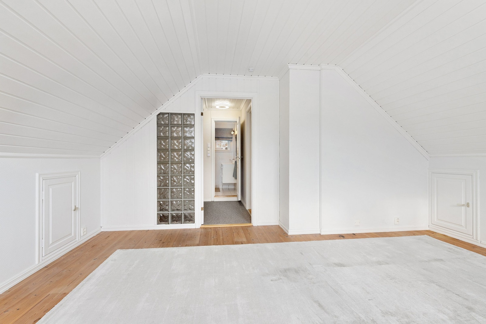 Det er glassbyggerstein i vegg mot gang/trapperom Galleribilde