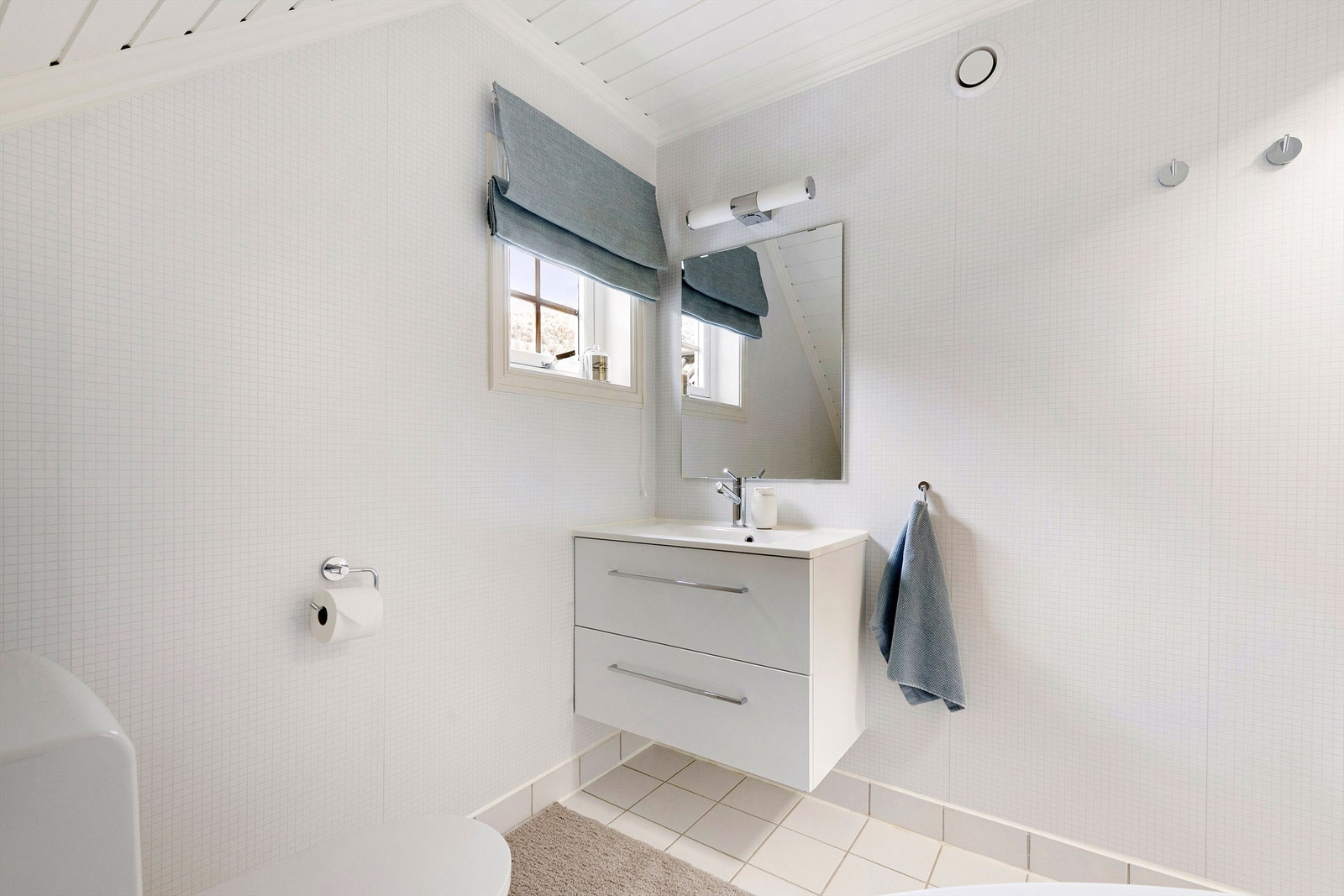 Bad i 2. etasje med servantinnredning med skuffer og speil med overlys over servant Galleribilde