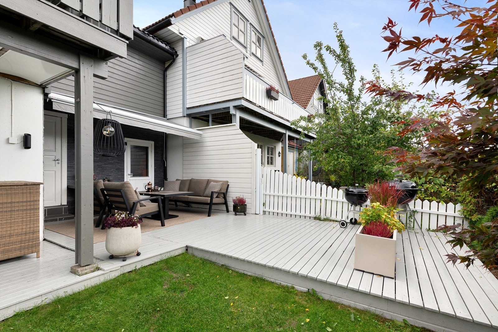 Pent opparbeidet og skjermet uteplass og markterrasse i hagen. Det er markise over deler av terrassen Galleribilde