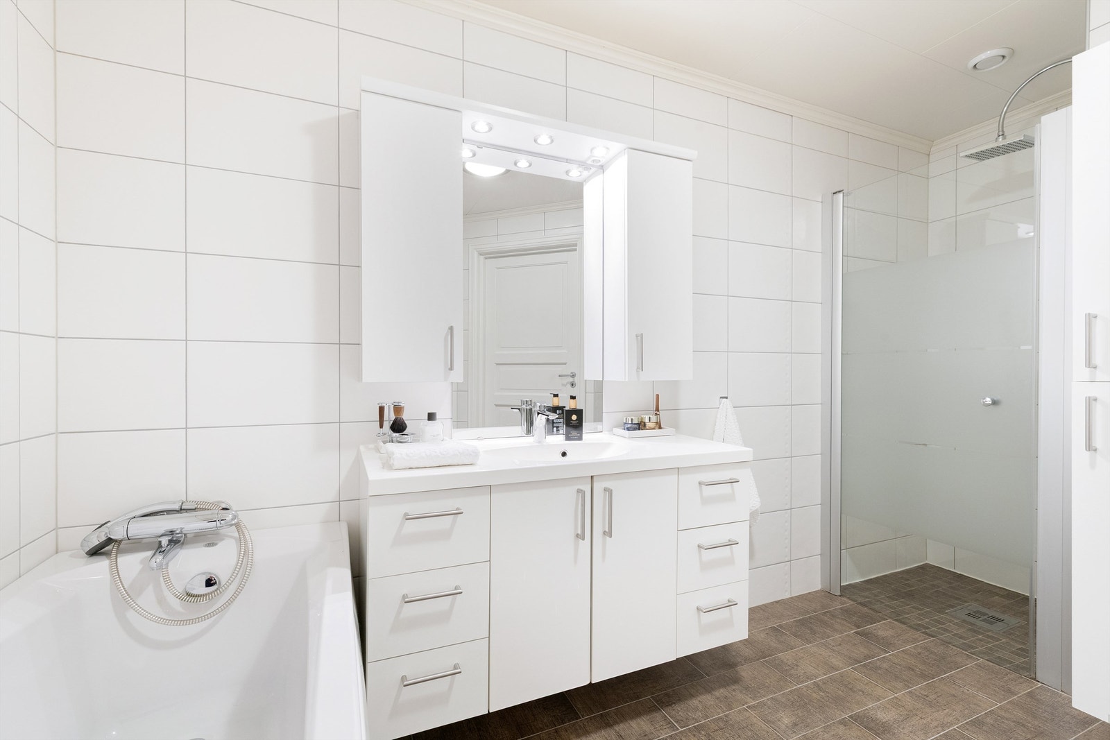 Innredning med god skapplass i underetasjen. Dusjnisje med glassdør og vegghengt dusjarmatur med hånddusj og regndusj. Galleribilde