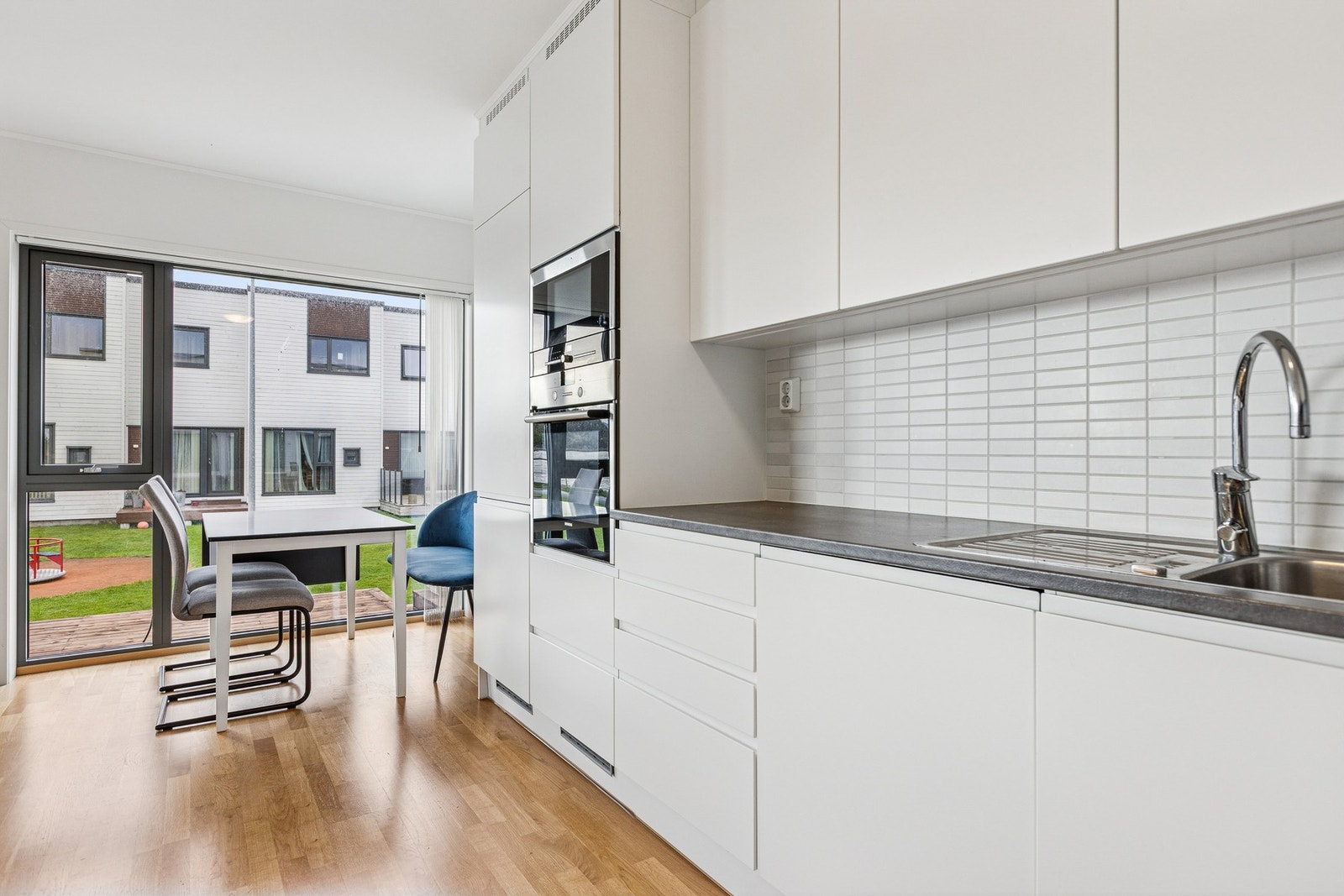 Delikat og moderne kjøkken med hvite glatte fronter. Galleribilde