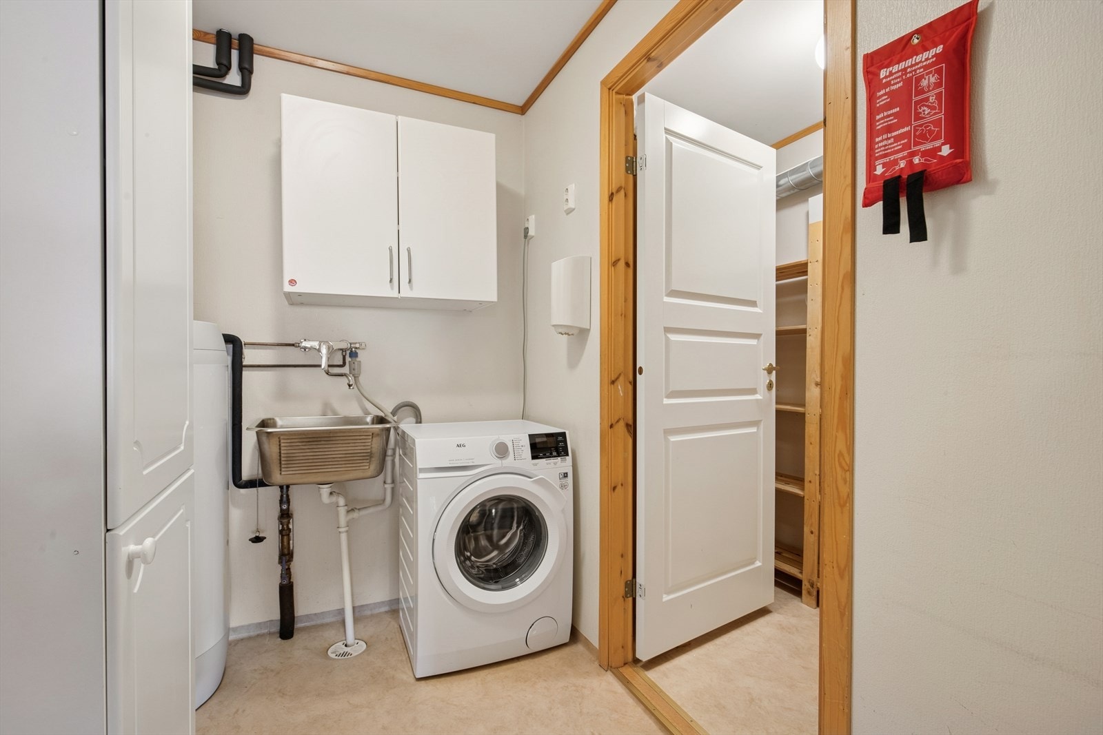 Rommet er innredet med opplegg for vaskemaskin, vegghengt utslagsvask og varmtvannsbereder. Galleribilde