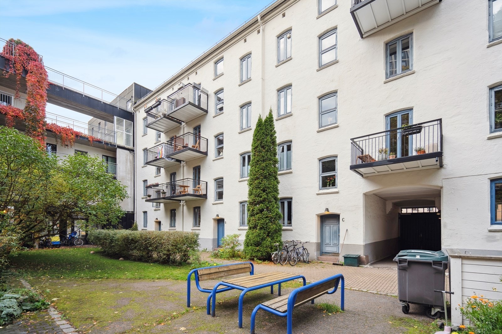 Grønn og koselig opparbeidet bakgård med sittegrupper og sykkelparkering. Galleribilde