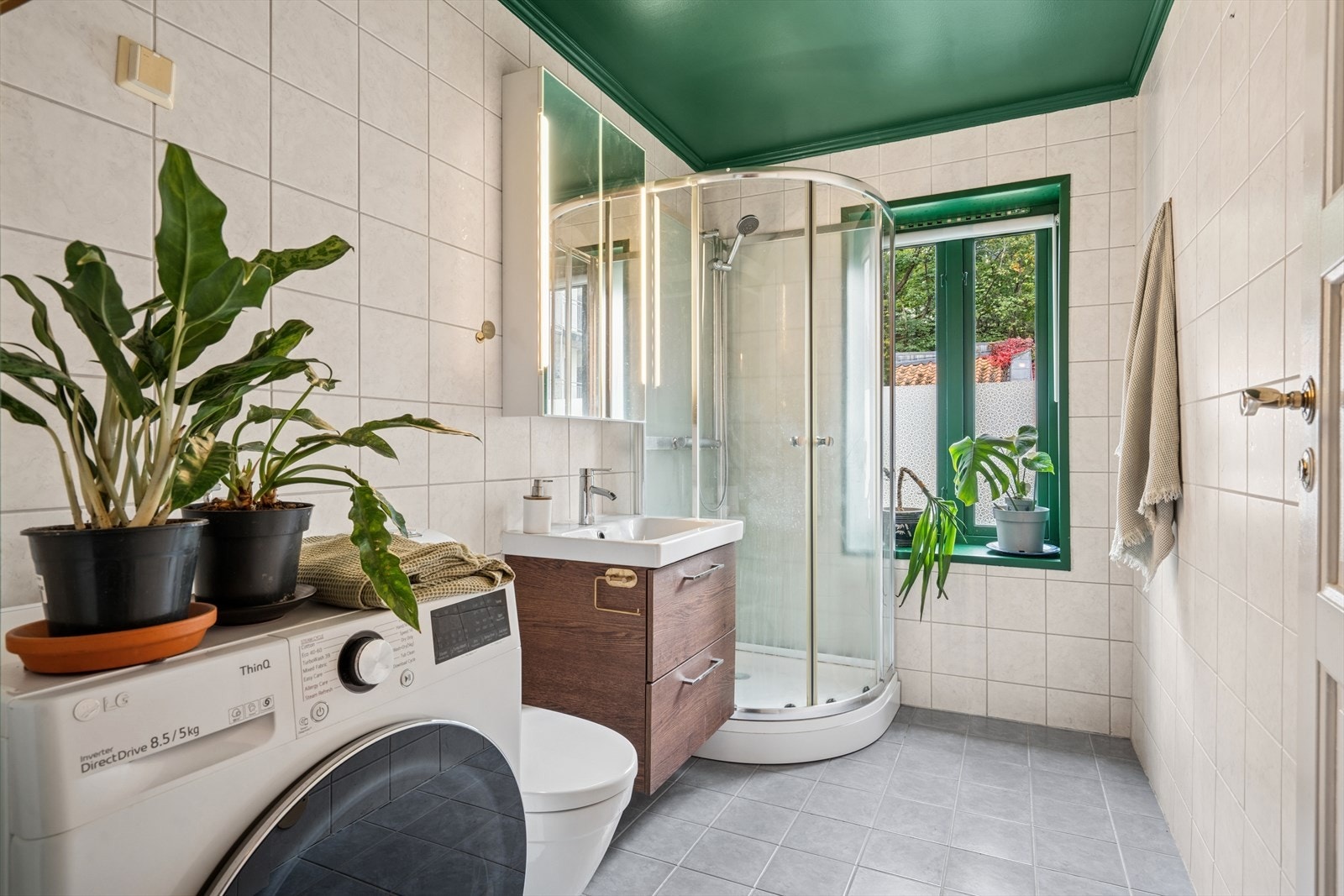 Badet har opplegg til vaskemaskin og baderomsinnredningen fra 2021. Galleribilde