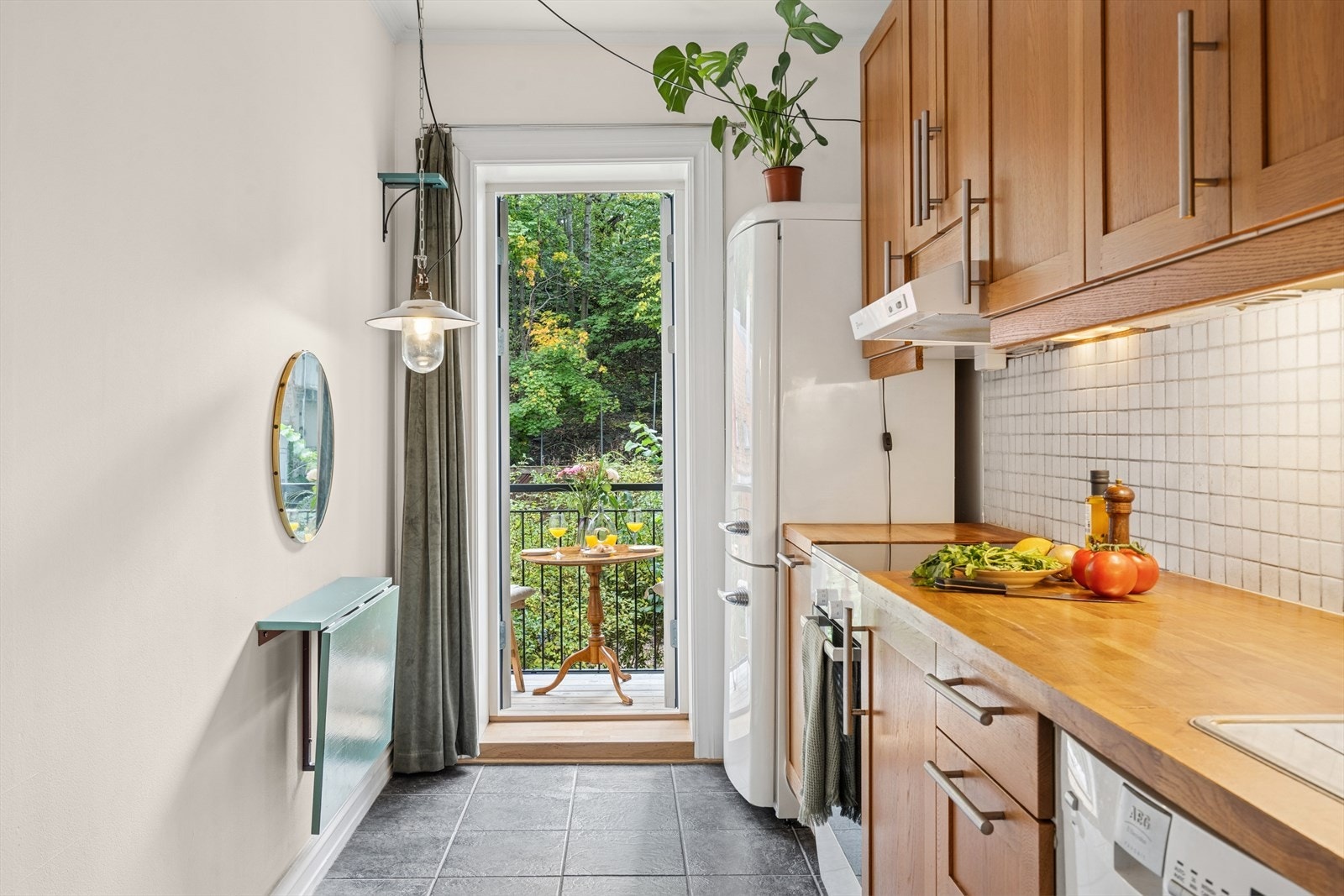 Fra kjøkkenet er det utgang til leilighetens balkong, som vender mot borettslagets grønne og koselige bakgård - perfekt for morgenkaffen. Galleribilde