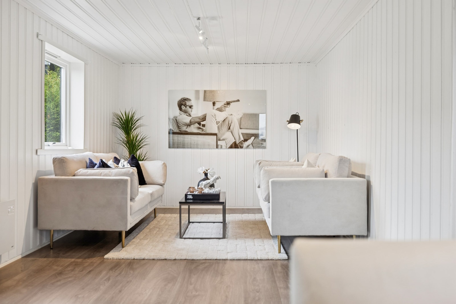 Gjennomgående laminatgulv og lyse panelvegger skaper en helhetlig stil. Galleribilde