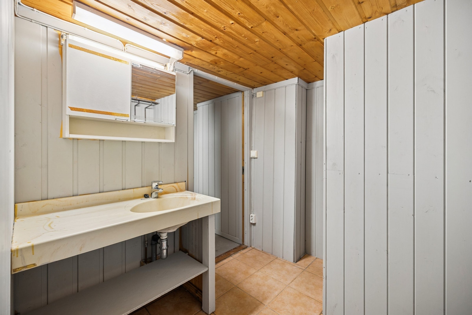 Praktisk toalettrom i kjelleren, utstyrt med servant og opplegg for vaskemaskin. Galleribilde