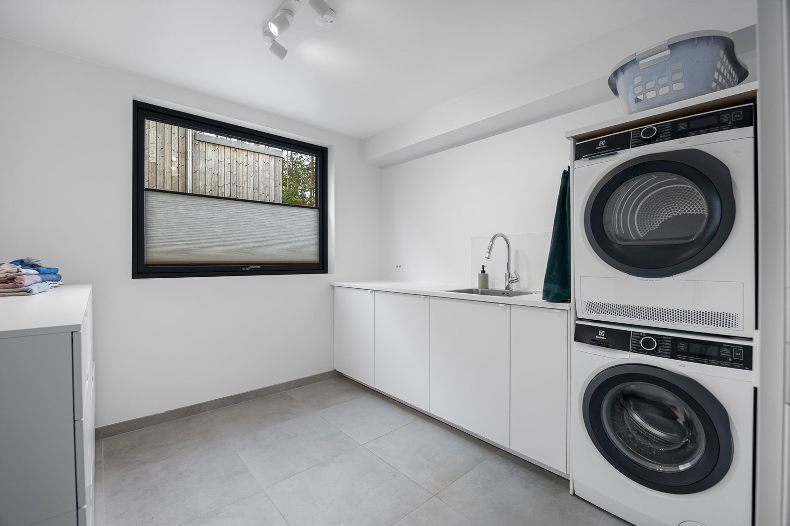 Praktisk løsning med tilliggende vaskerom som har fast innredning, servantvask og fliser på gulv. Galleribilde