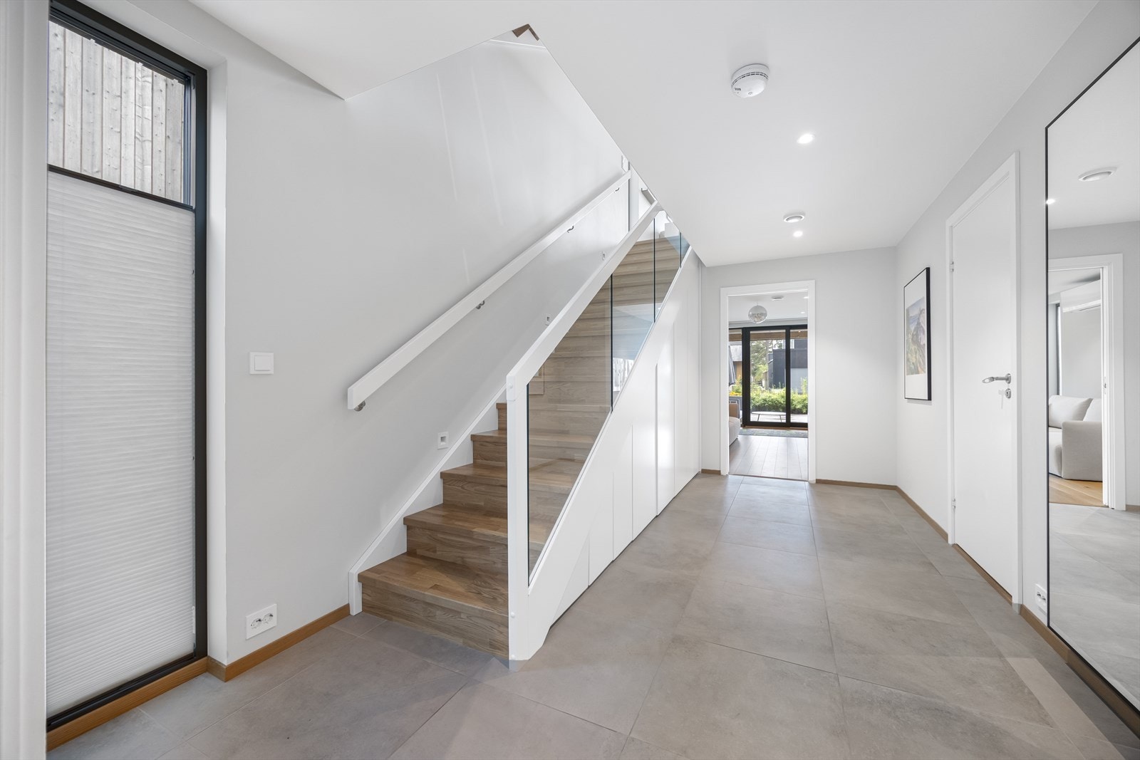 Romslig hall med trapp til hovedetasje og praktisk lagringsplass under trapp. Galleribilde