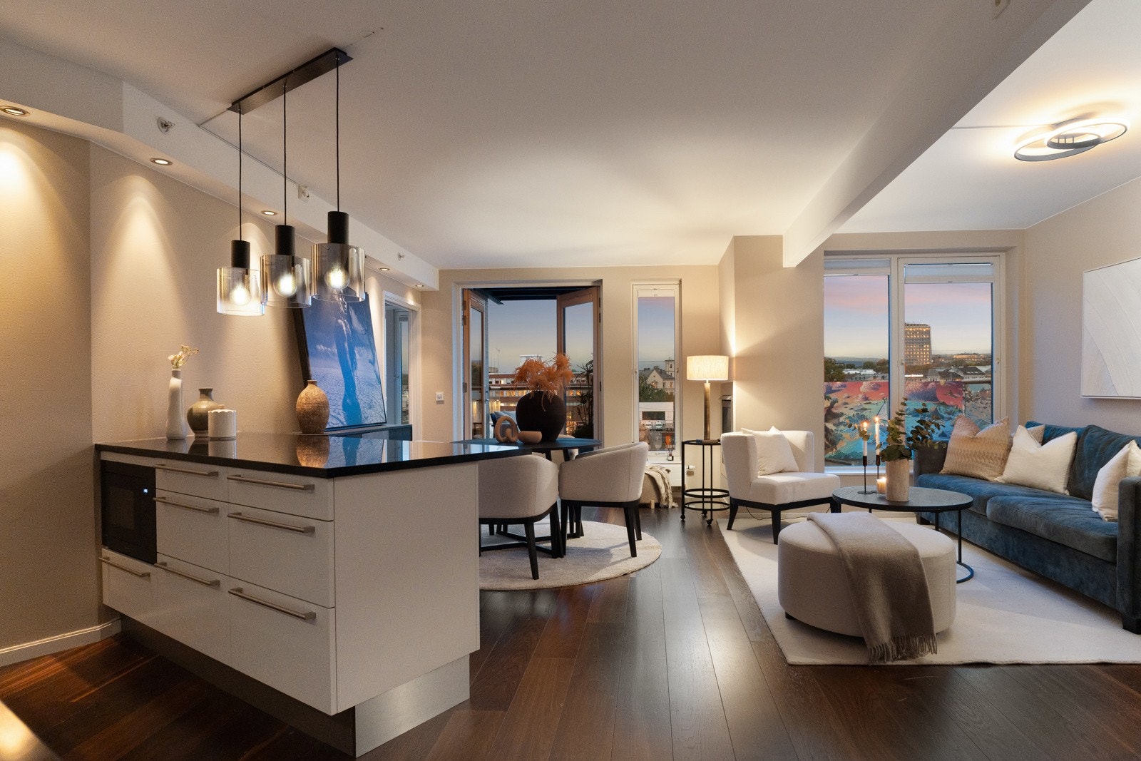 Stue og kjøkken ligger i en åpen og funksjonell løsning som gir et sosialt og trivelig oppholdsrom. Det er god plass til både sofagruppe og spisebord, og en stilren gasspeis bidrar med både varme og stemning. Galleribilde