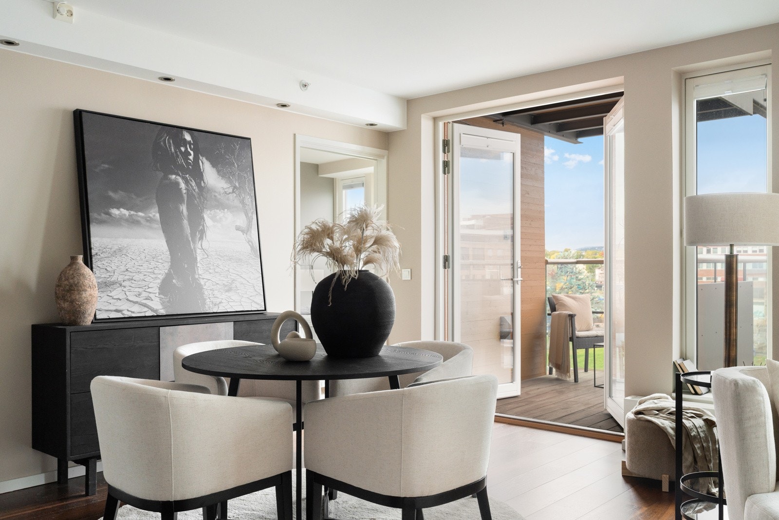 De store balkongdørene åpner opp rommet mot uteplassen og skaper en sømløs overgang mellom stue og balkong i sommerhalvåret. Galleribilde