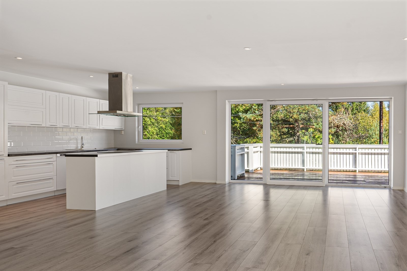 Moderne kjøkken med integrerte hvitevarer, samt åpen løsning mot stue. Galleribilde