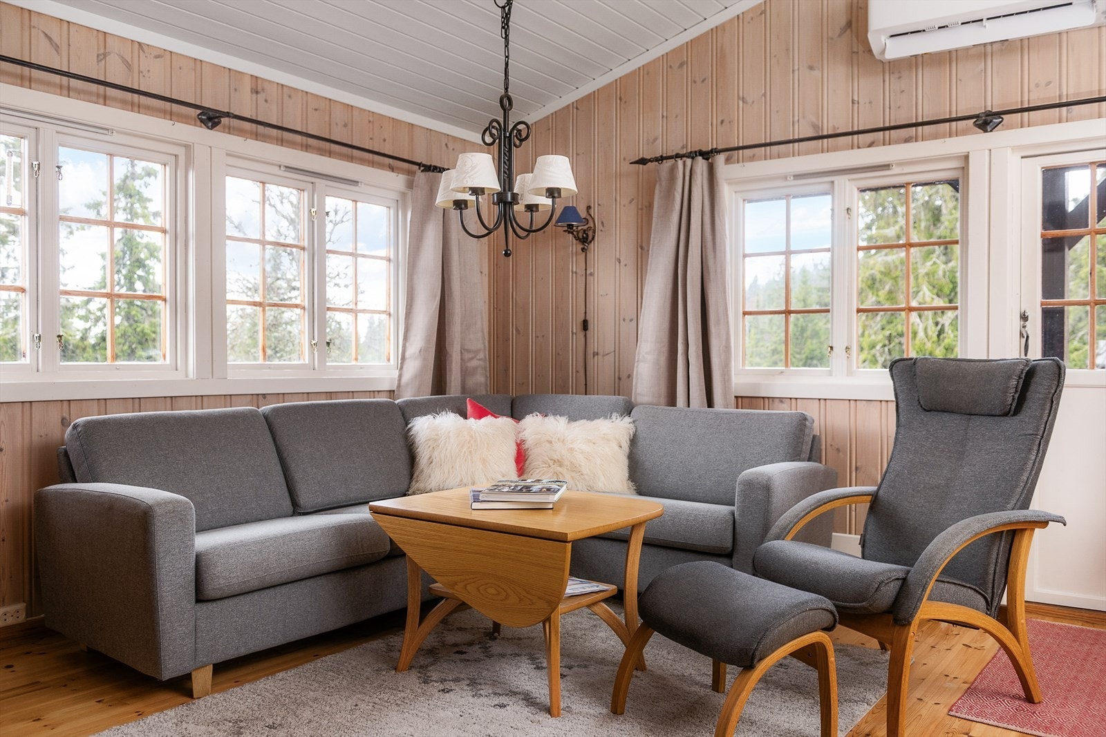 Hyggelig sofakrok foran vinduene. Varmepumpe for effektiv oppvarming av hytta. Galleribilde
