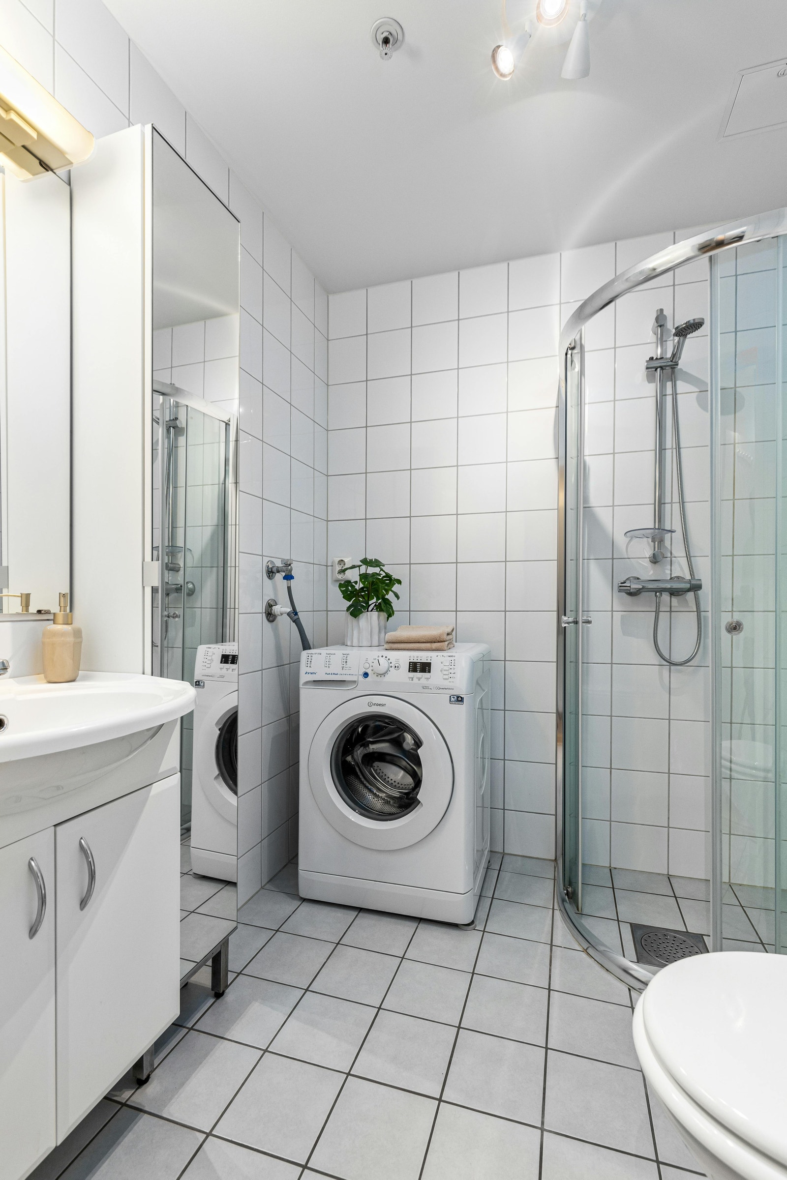 Flislagt baderom med opplegg til vaskemaskin. Galleribilde