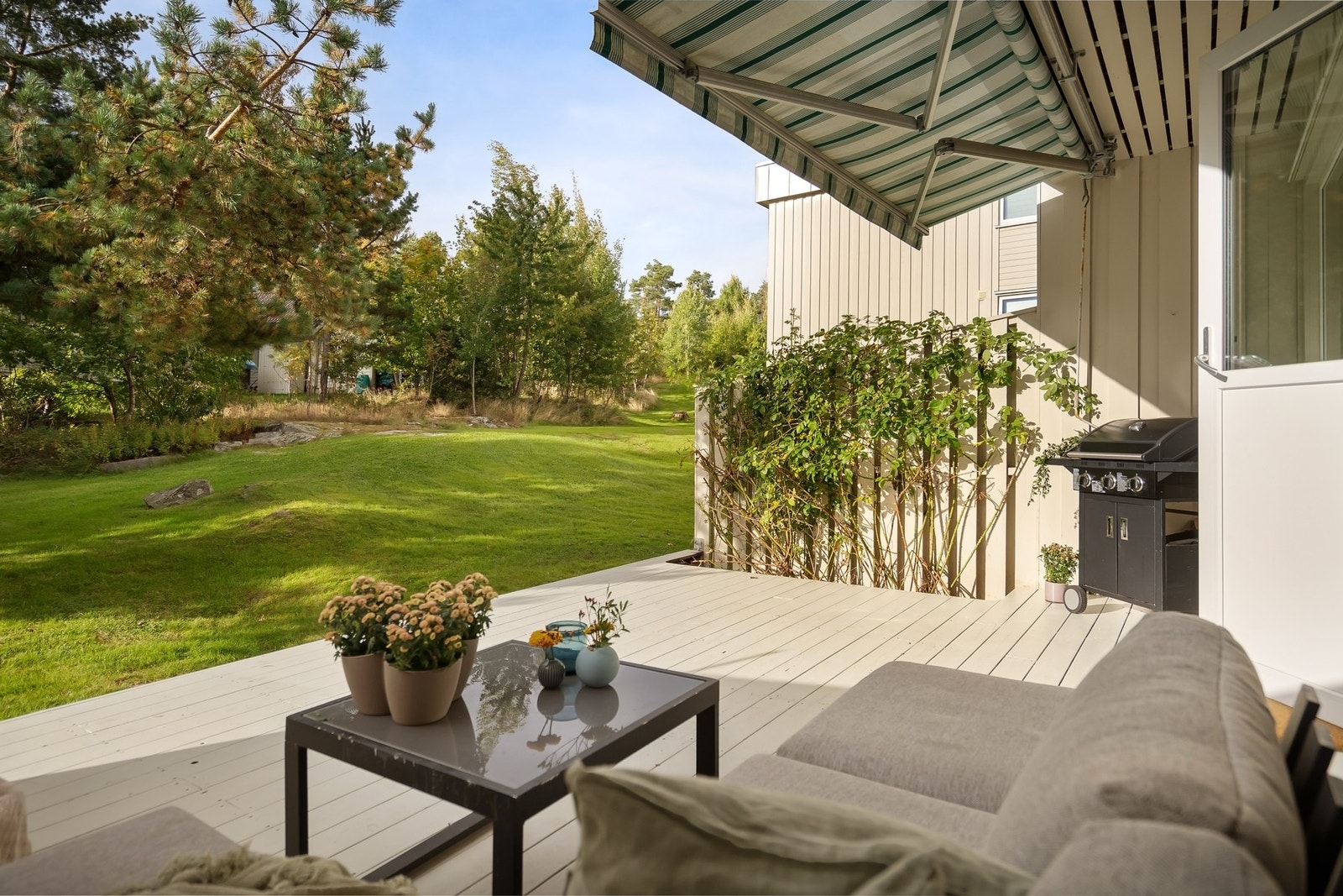 Hyggelig uteplass på bakkeplan med markise og plass til sittegruppe. Galleribilde