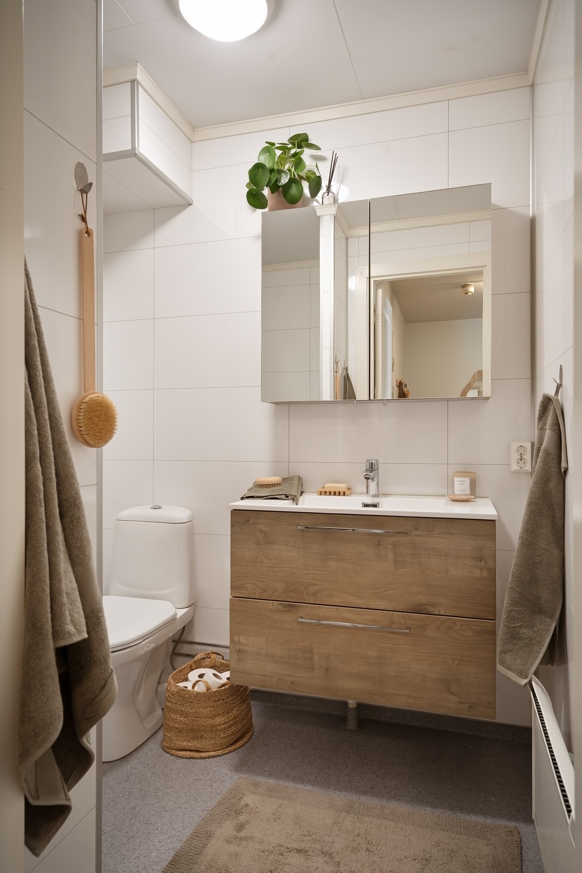 Delikat bad med servant, speilskap, toalett og dusjhjørne. Galleribilde