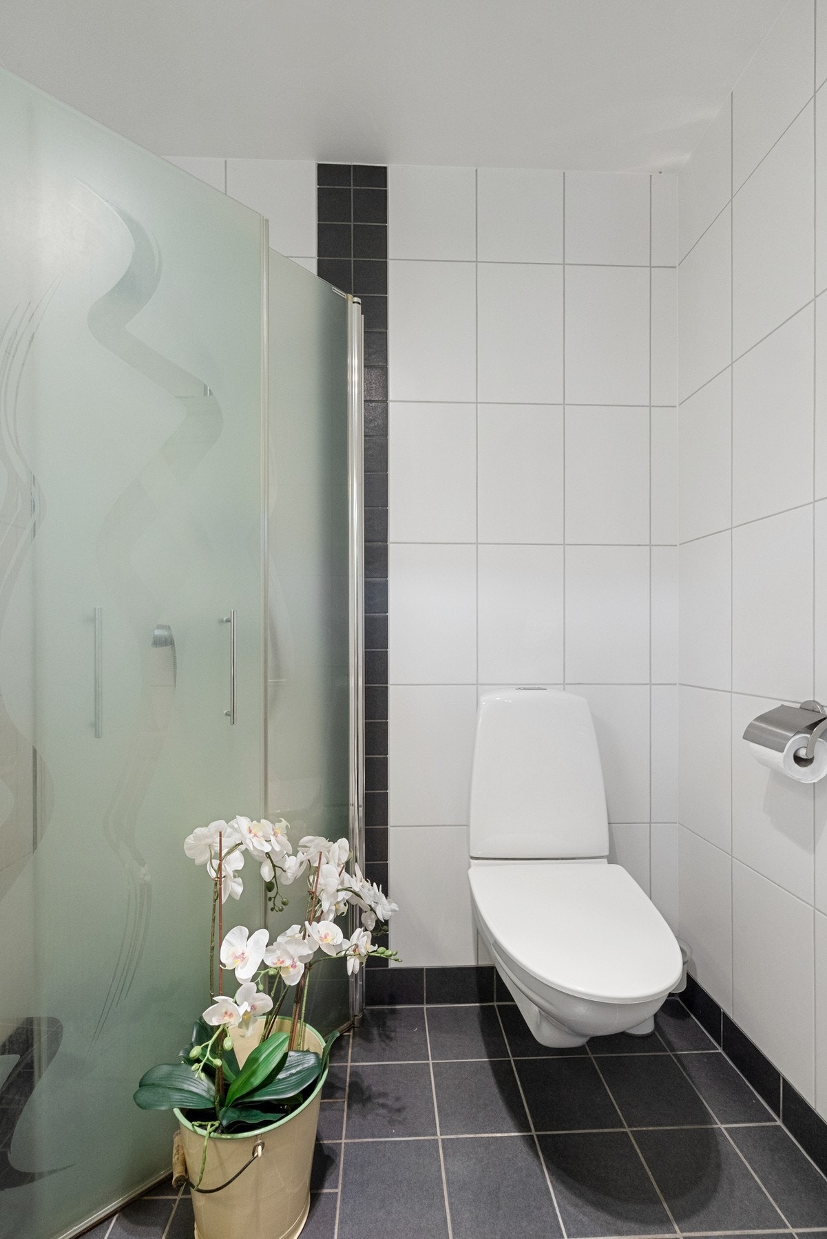 Rommet er utstyrt med vegghengt toalett, baderomsinnredning, opplegg for vaskemaskin og dusj m/innfellbare dusjvegger. Galleribilde