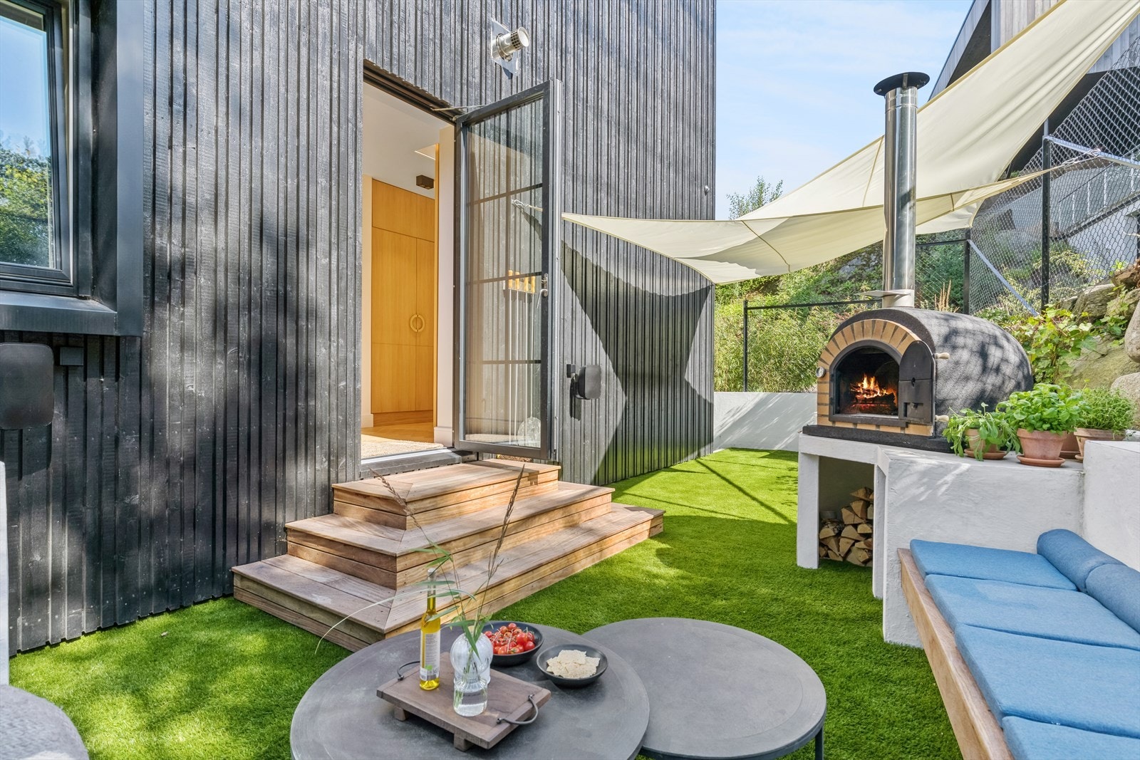 På baksiden av huset med utgang fra 2. etasje, sitter du lunt og godt om du blir lei av sjølukten, kan du ha eksempelvis ha pizzafest i bakgården. Galleribilde