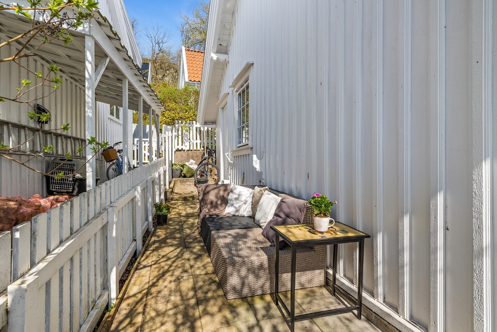 Bjerggata 15 har en hellelagt uteplass på 1.25 m. som går langs husveggen mot nordvest (gjerde vil bli flyttet noe nærmere enn hva som fremkommer på vedlagte bilde) Galleribilde