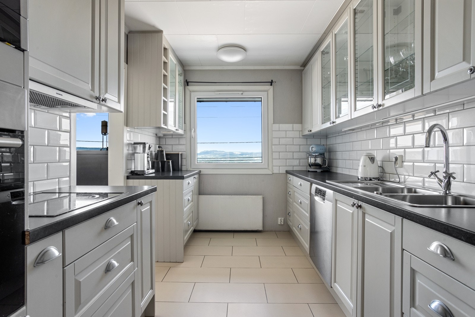 Pent lyst kjøkken fra 2013 med integrert platetopp, mikrobølgeovn og stekeovn. Galleribilde