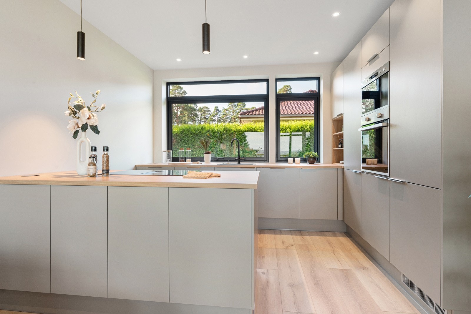 innredning på kjøkken har godt med naturlig lys fra store vindusflater Galleribilde