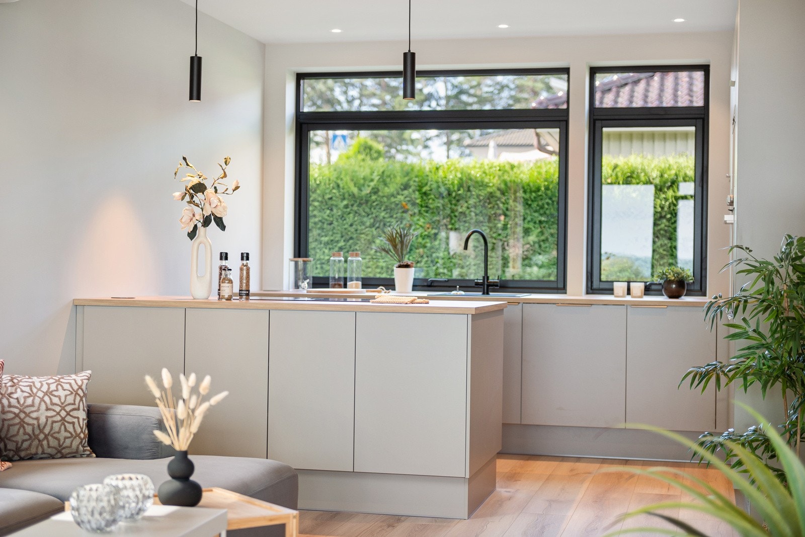 Kjøkken har pen innredning med kjøkkenøy mot stuedel Galleribilde