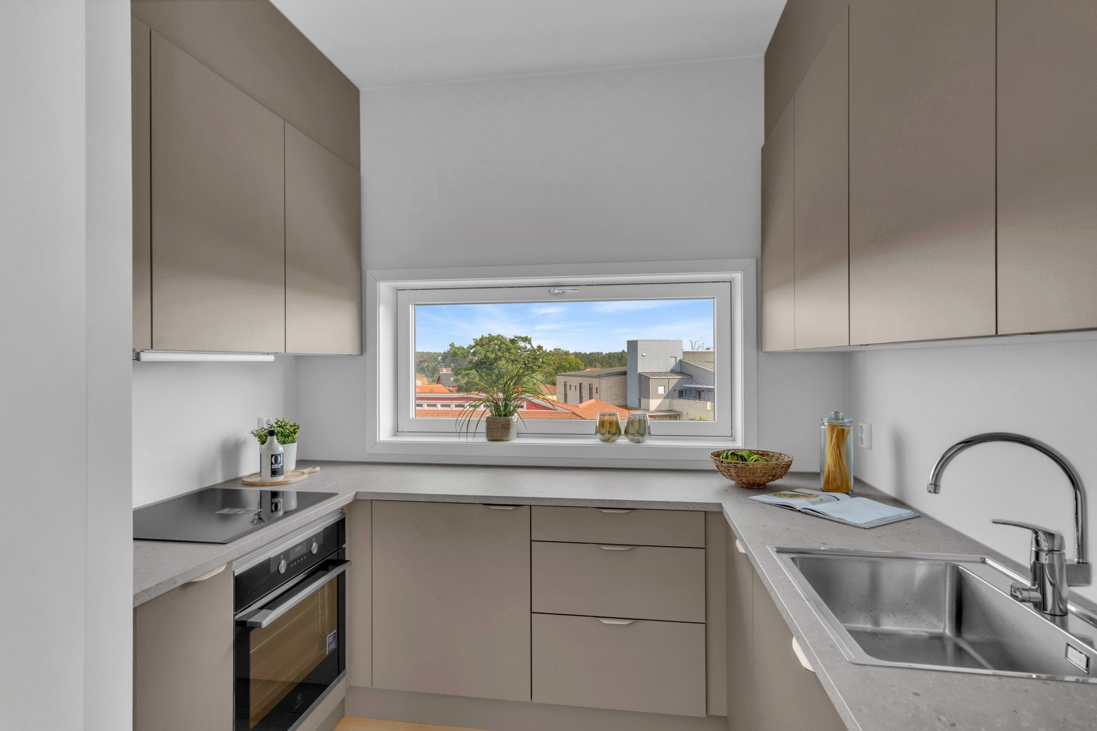 Det er integrerte hvitevarer som induksjonsplatetopp, stekeovn, oppvaskmaskin og kombiskap Galleribilde