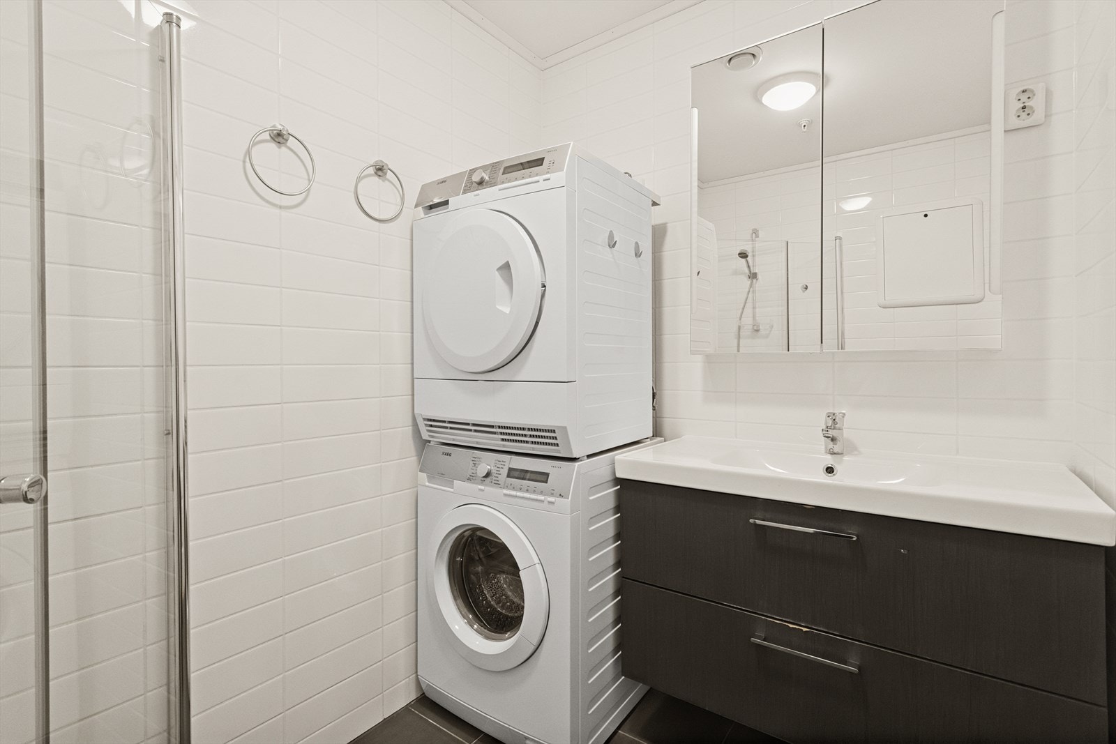 Badet har dusjvegger av glass, vegghengt toalett, innredning med servant samt opplegg for vaskemaskin. Mekanisk avtrekk via balansert luftagregat. Galleribilde