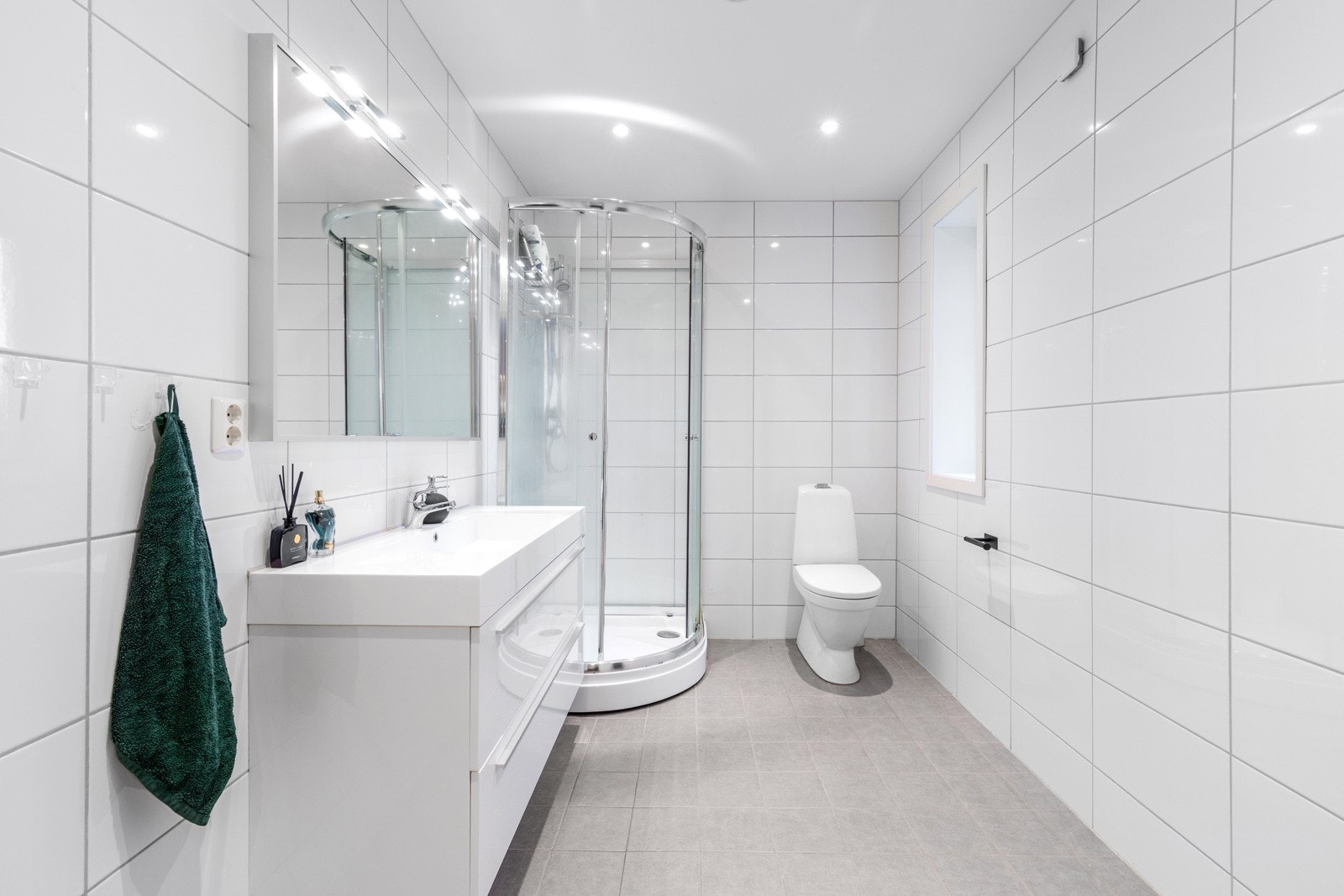 Badet er fra byggeår og har tidløse, flislagte overflater med varmekabler i gulvet Galleribilde