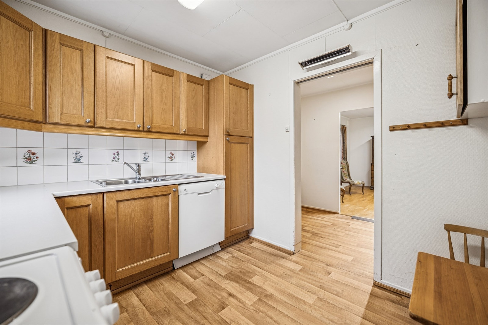 Rommet har laminat på gulv, fliser over benk og plass til frittstående hvitevarer. Galleribilde