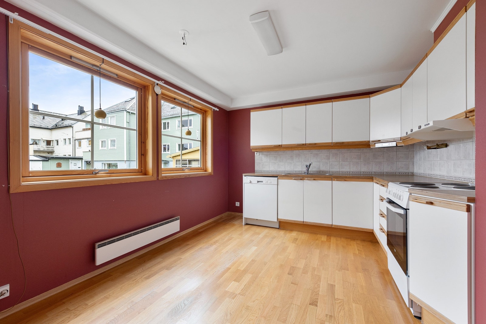 Kjøkkeninnredning fra Norema med profilerte fronter og benkeplate av laminat. Det er plass til spisebord i kjøkken Galleribilde