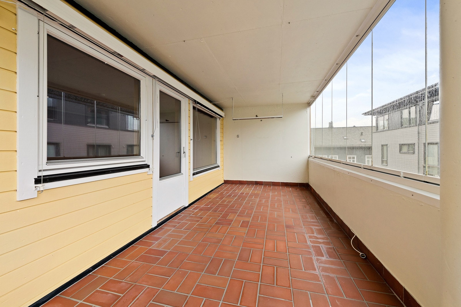 Flislagt terrasse som er innglasset Galleribilde