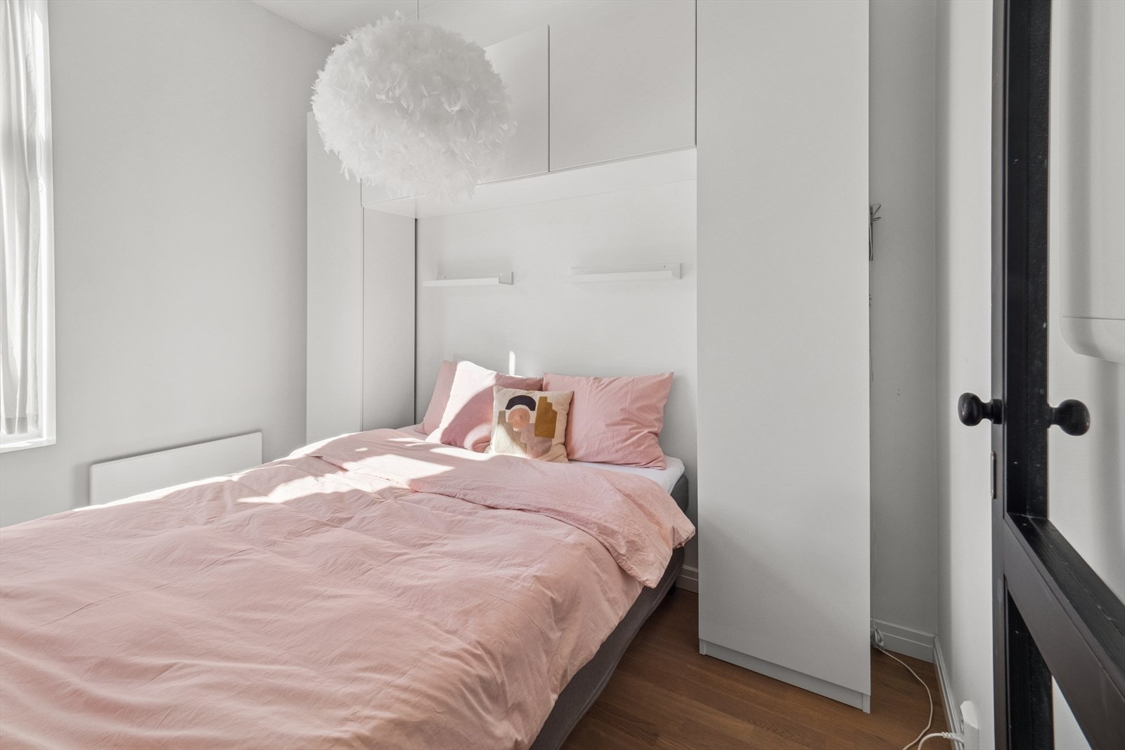 Rundt og over sengen er det skap som gir rikelig med oppbevaringsplass og bidrar til et ryddig og funksjonelt soveromsmiljø. Galleribilde