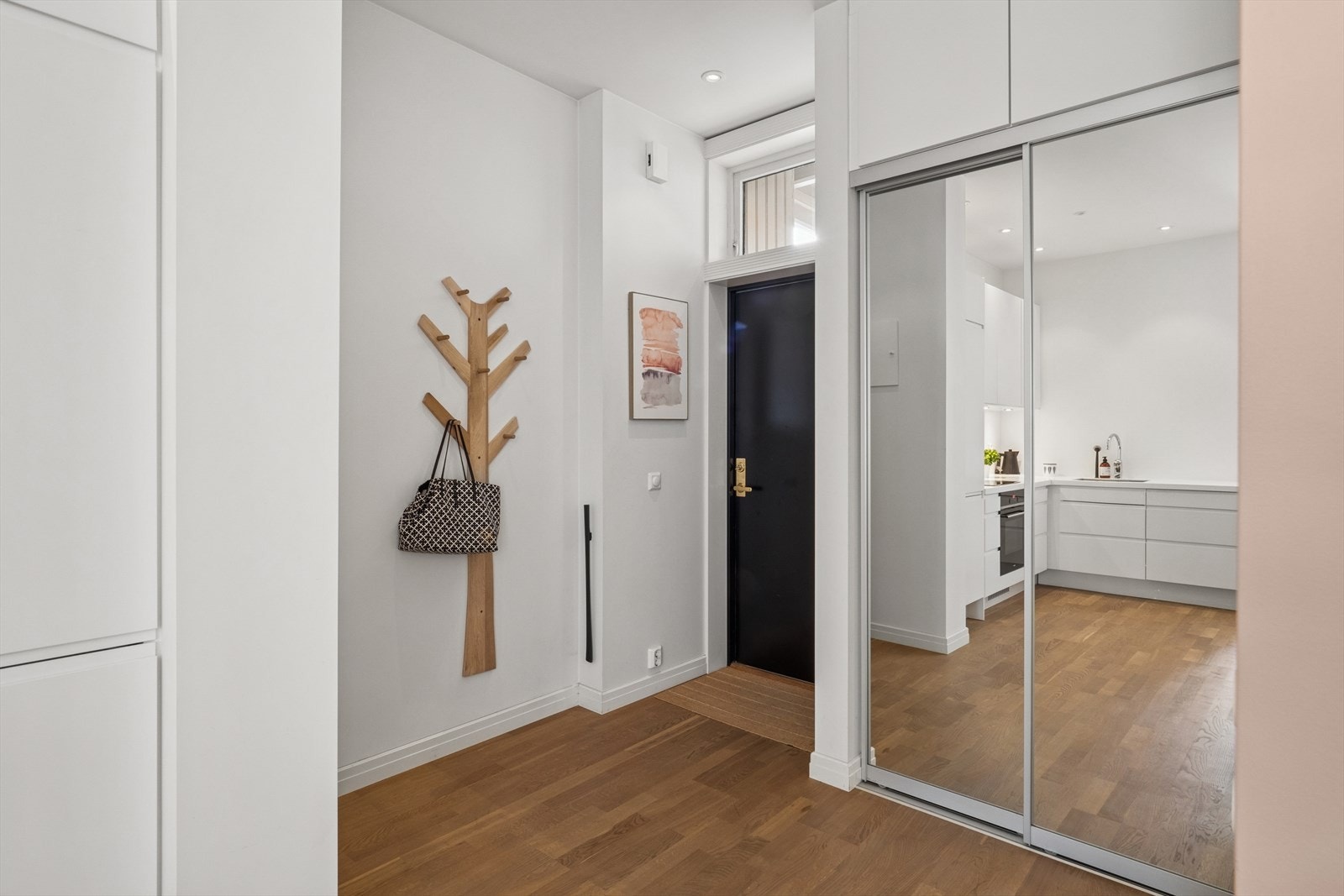 Lys og luftig entré med moderne preg - nøytrale farger og vindu over inngangsdøren som gir ekstra dagslys inn i rommet. Galleribilde