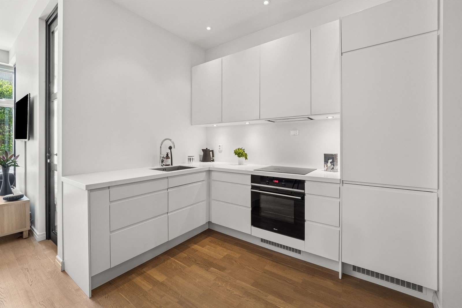 Integrerte hvitevarer som komfyr, koketopp, oppvaskmaskin og kombiskap med kjøl/frys. Galleribilde