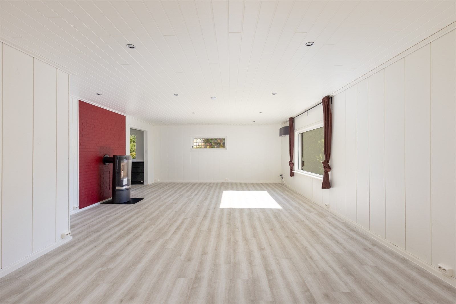 Stua har utsikt mot den hyggelige hagen, og det er utgang til overbygget terrasse med plass til utemøblement. Herfra er det trapp ned til hage og gårdsplass. Galleribilde