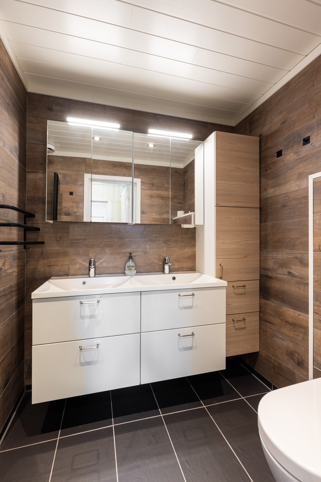 Boligen har et lunt og varmt baderom som er helfliset med varmekabler i gulvet. Det er god oppbevaringsplass i innredning med dobbel servant, samt i høyskap og speilskap med overlys. Galleribilde