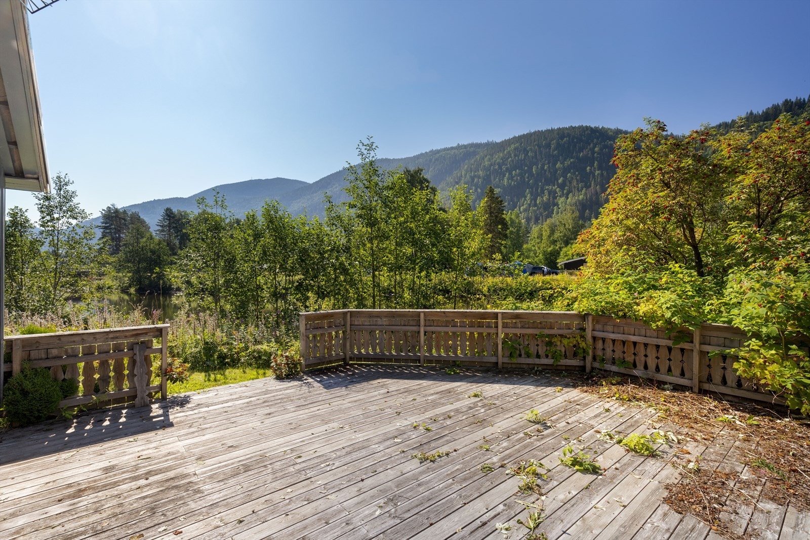 I bakkant av garasjen er det etablert en utestue med tilliggende terrasse. Legg merke til utsikten til elva. Galleribilde