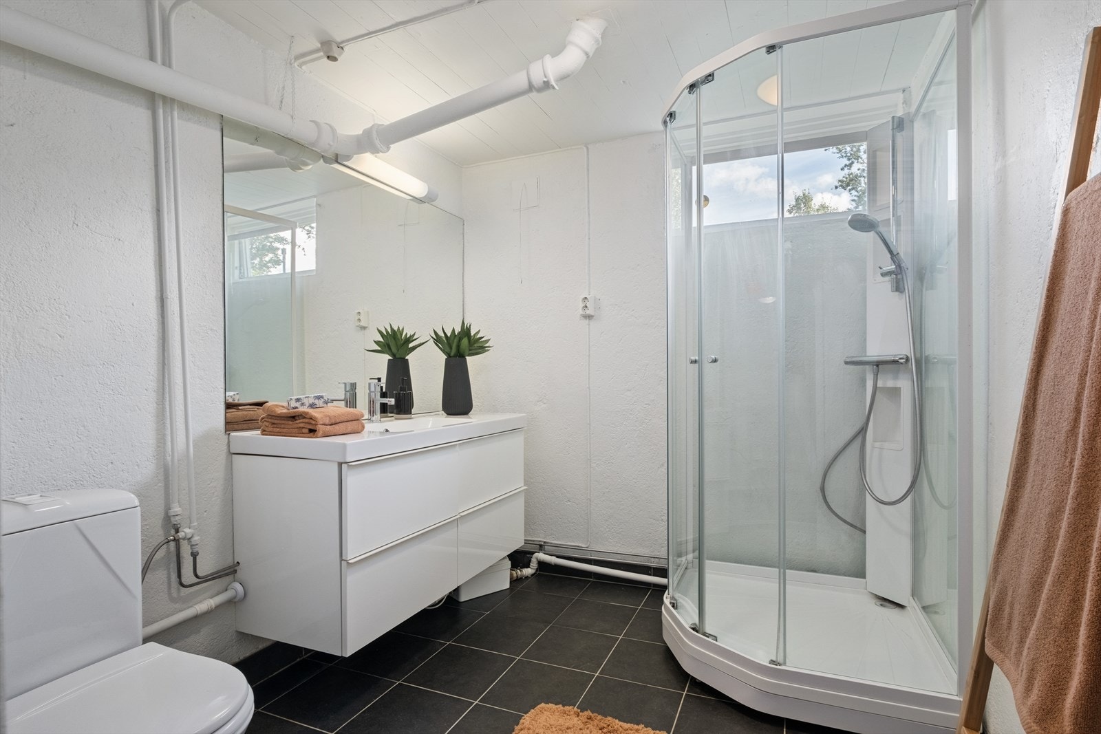 Baderom nr. 2 i underetasje:
Gulv med keramiske fliser, vegger av malt mur, malt panel i himling. Dusjkabinett. Servantskap og toalett. Galleribilde