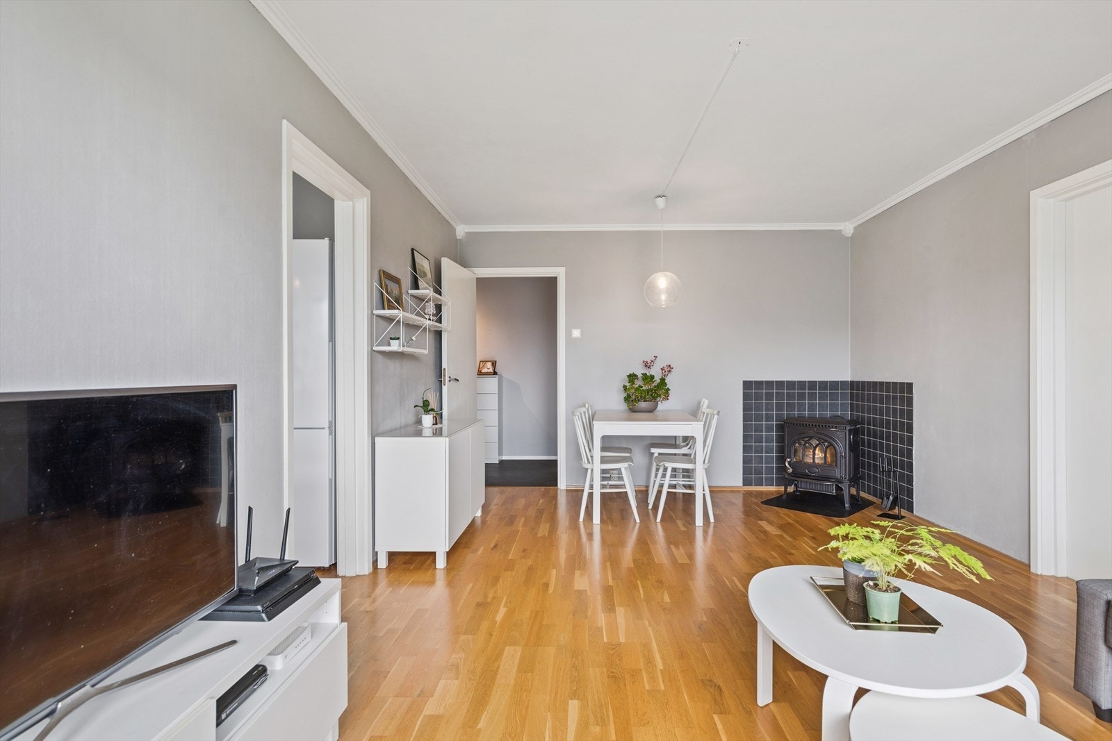 Lys og trivelig stue med god plass til spisebord. Den gode varmen får du fra peisovnen i hjørnet. Galleribilde