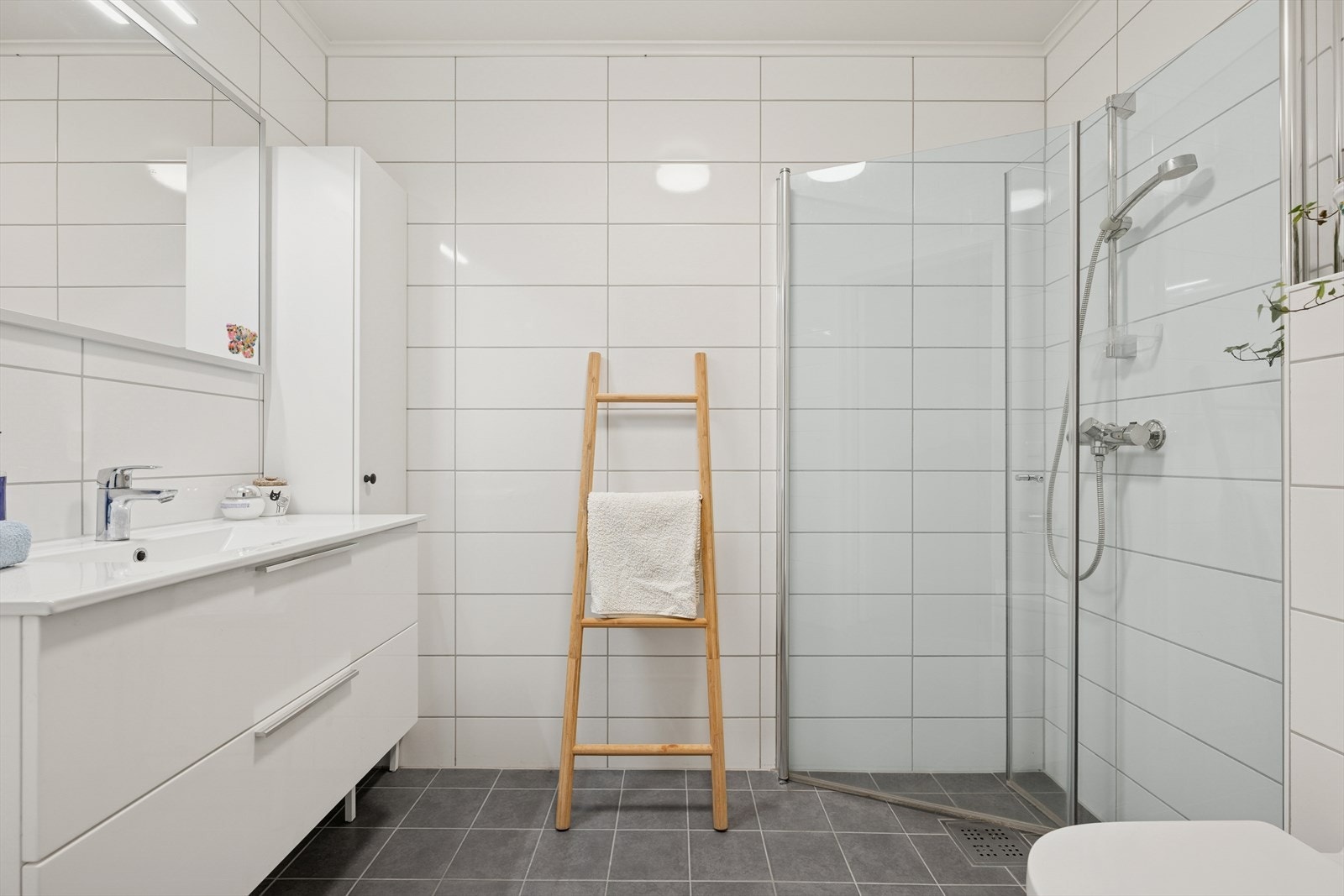 - Baderommet har flislagte overflater som gir et tidløst uttrykk. Elektriske varmekabler i gulvet sørger for behagelig varme og økt komfort året rundt - Galleribilde