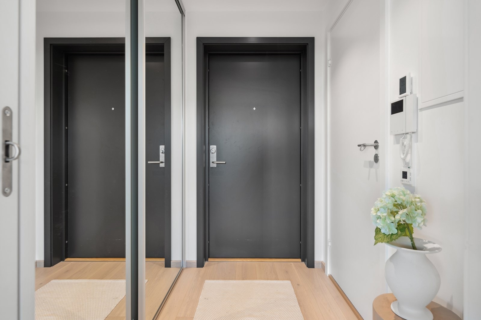 Lys og delikat entré med skyvedørsgarderobe og callingsystem. Galleribilde