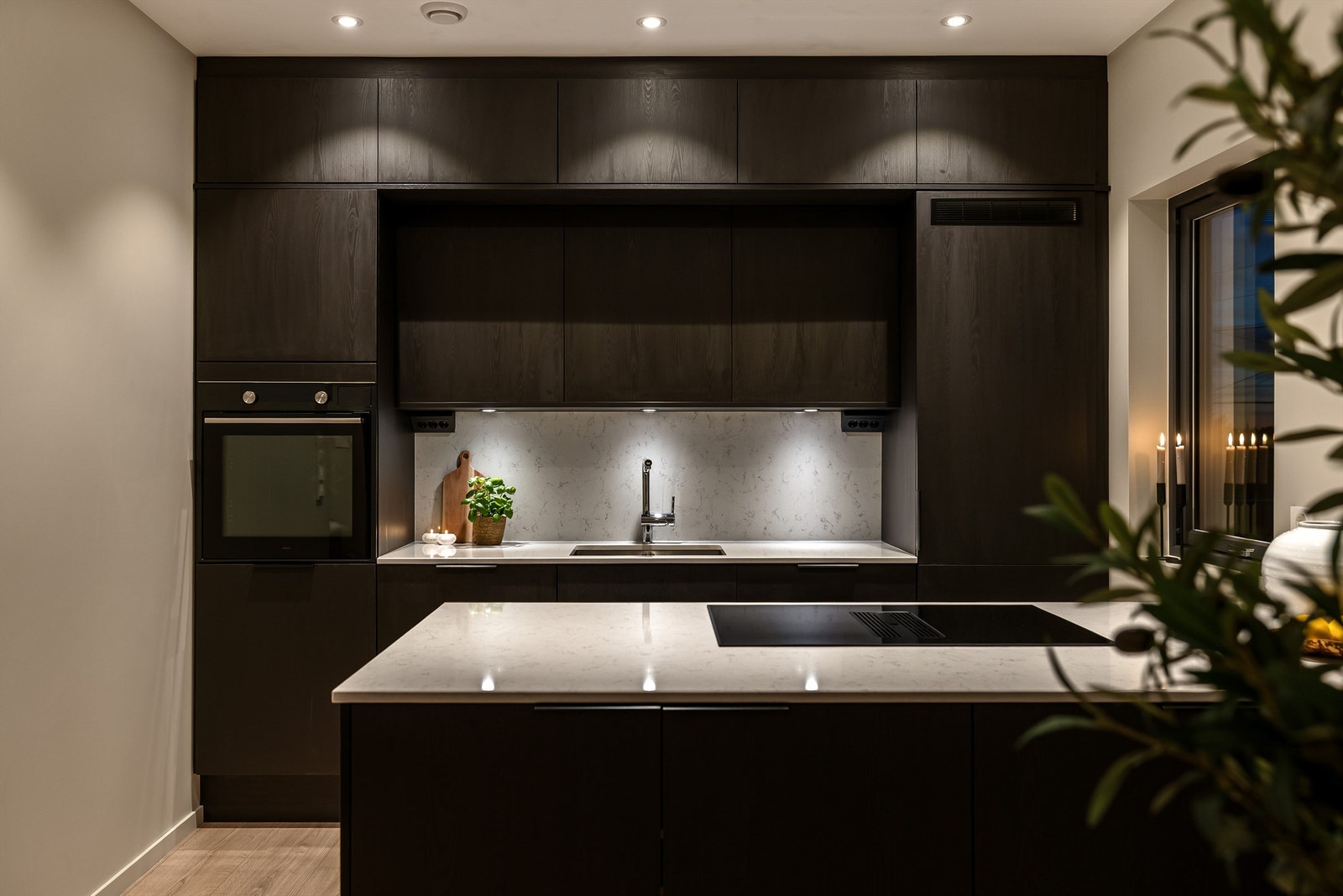 Kjøkkenet fremstår eksklusivt med mørke fronter, og lys stein benkeplate. Galleribilde